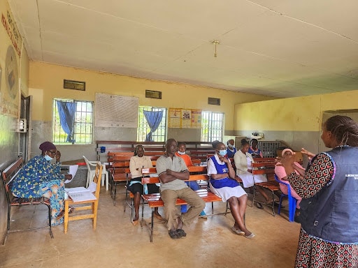 A Health Access Connect Field Coordinator (in a navy blue jacket) conducts on-site ASRH training at Kinoni Health Centre III on 4 March 2026.